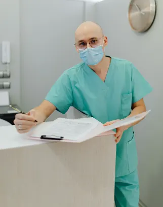 Medical professional in teal scrubs preparing billing paperwork
